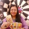 Tarot card reader with vibrant backdrop.